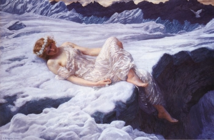 A woman with flower crown dressed in a white, laying on white foam.